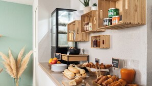 Un buffet de petit-déjeuner proposant une variété d’aliments, notamment des fruits, des viennoiseries et des boissons.