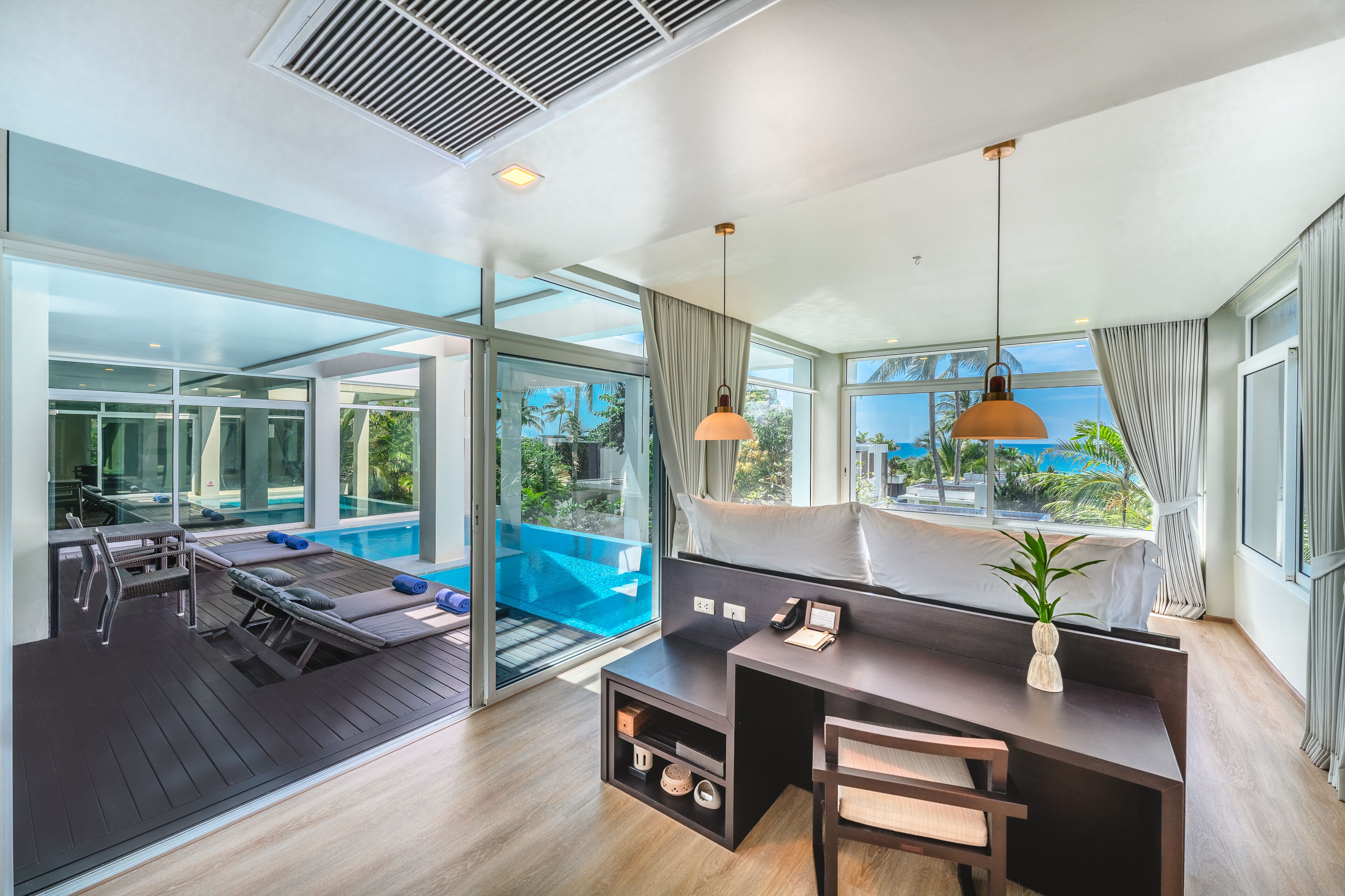 A modern room with a pool, a desk, and a view of the outdoors.