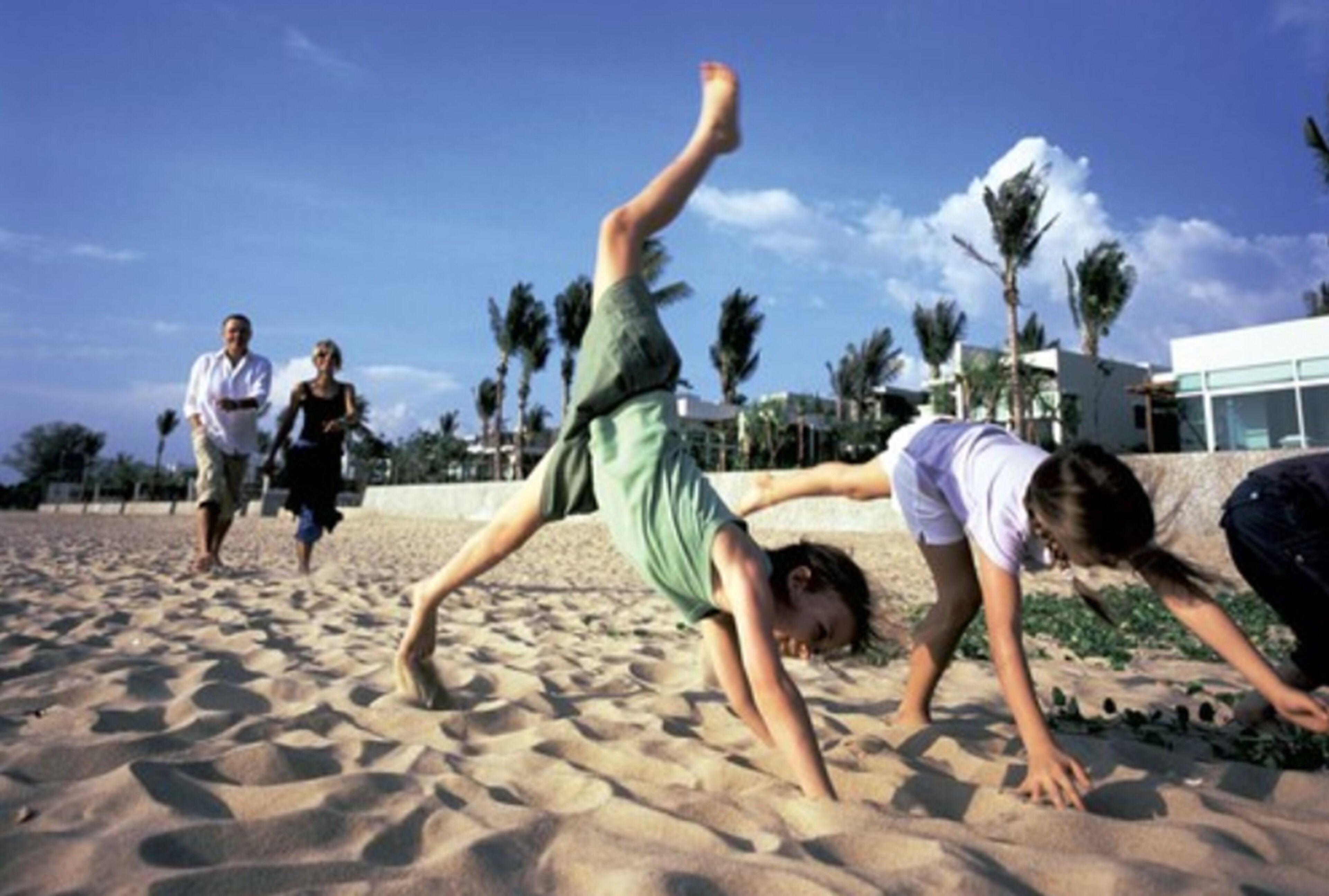 Ein Strandbild, das Menschen bei sportlichen Aktivitäten zeigt.