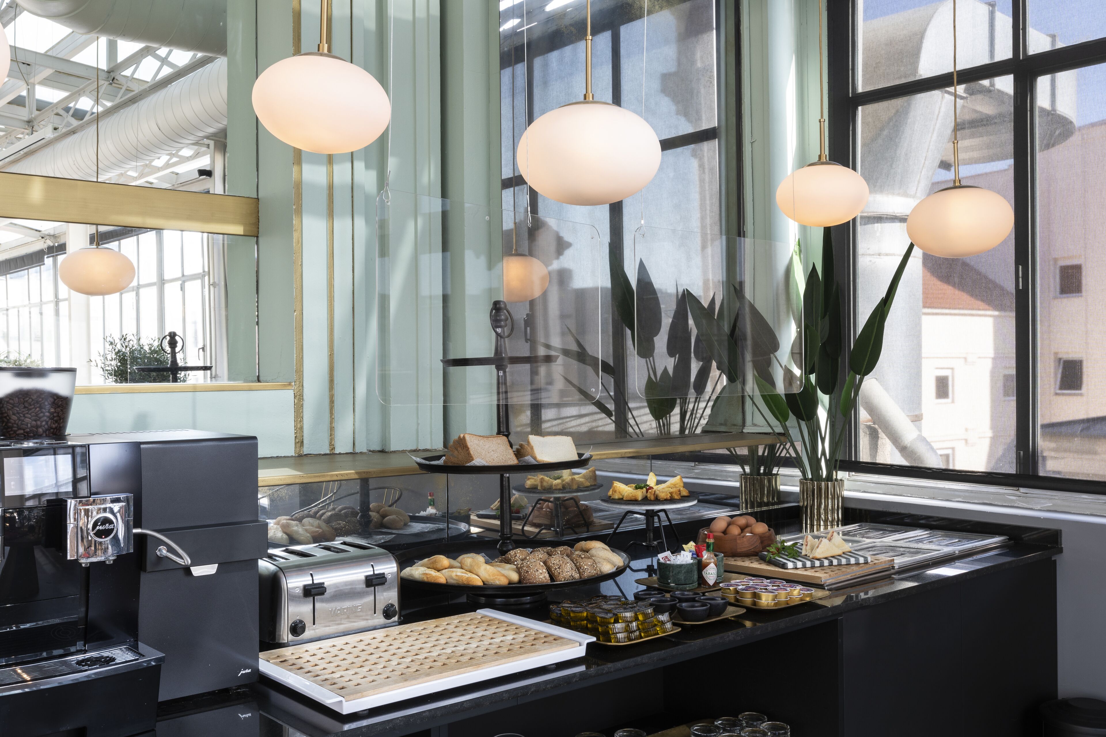A breakfast bar with a coffee machine, toaster, and various food items.