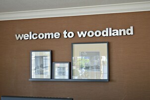 Un letrero con la frase 'welcome to woodland' encima de fotografías enmarcadas.