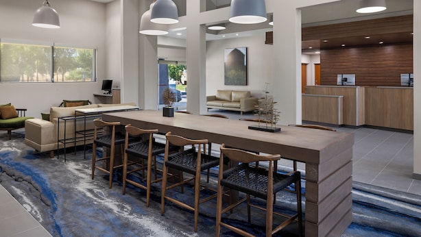 Una cocina moderna con armarios de madera, una isla central e iluminación colgante.