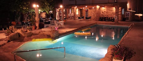 Una piscina al aire libre, sombrillas, tumbonas