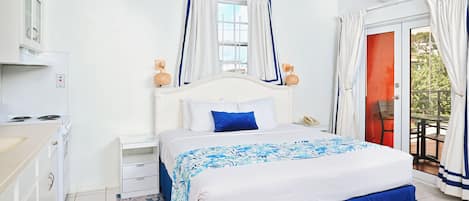 A bedroom with a bed, nightstands, a dresser, an air conditioning unit, and a view of the outdoors.