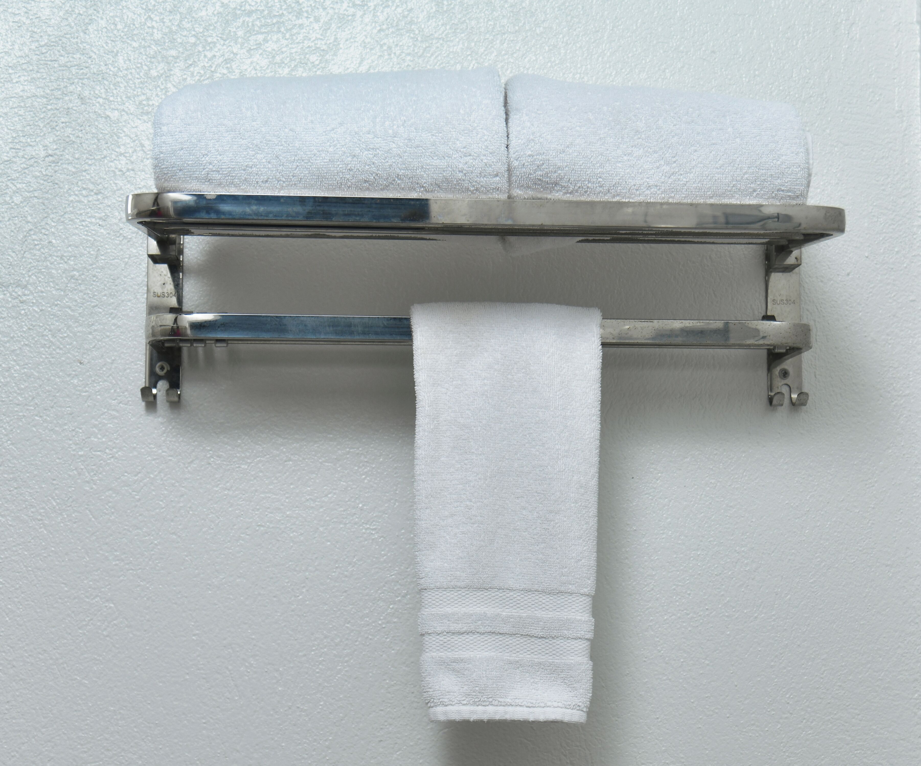 A towel rack with two towels and a single towel hanging from it.