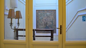 A room with a yellow door, a framed artwork on the wall, and a lamp on a table. - Residence Michelangiolo (Florence)