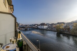 A balcony with a view of a river, buildings, and a bridge. - Boutique Hotel KARL (Lucerne)