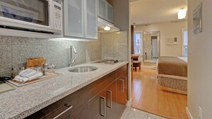 A modern kitchen with granite countertops, a double sink, and a microwave.