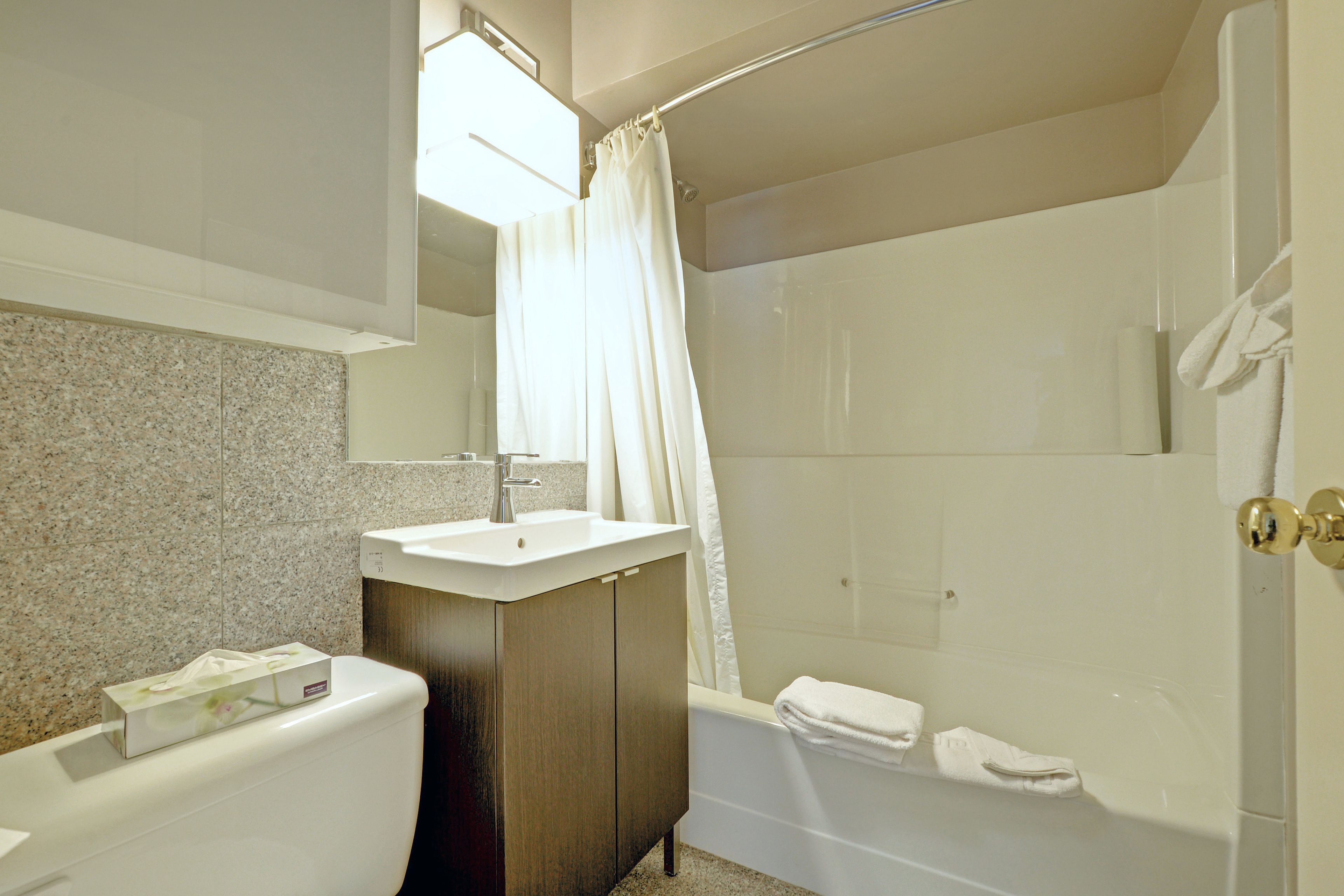 Une salle de bain avec des toilettes, un lavabo et une baignoire.