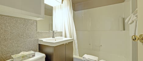 A bathroom with a toilet, sink, and bathtub.