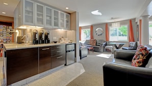 A modern kitchen with a central island, built-in appliances, and a dining area with a sofa and table.