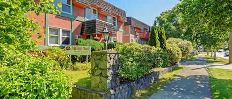 Een rij kleurrijke herenhuizen met een bordje voor 'Helm's Inn' en 'Mount Royale Building'.