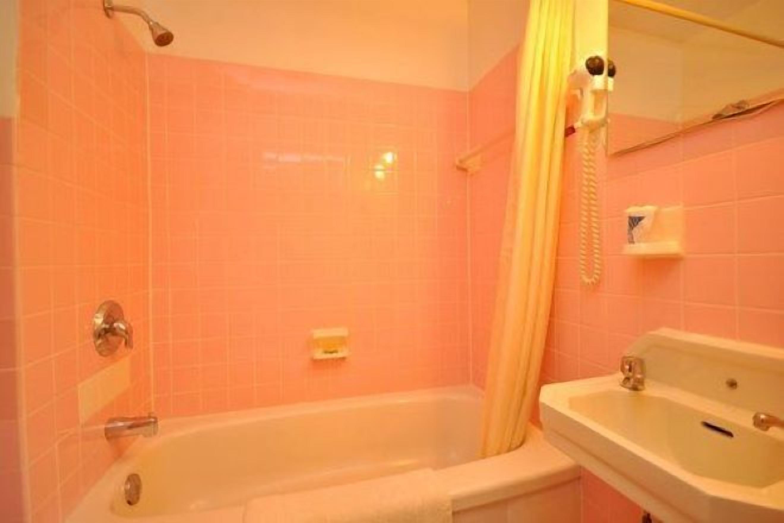 A bathroom with a bathtub, a sink, and a shower curtain.