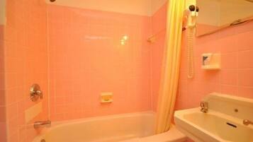 A bathroom with a bathtub, a sink, and a shower curtain.