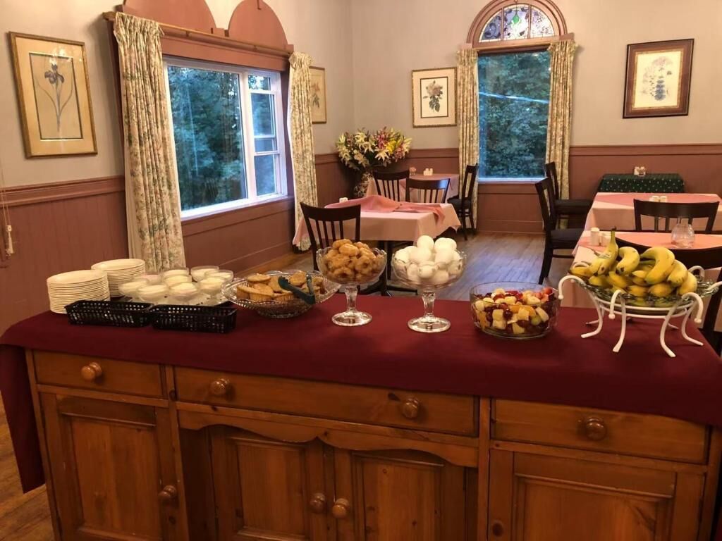 A buffet setup with various food items and a red tablecloth.