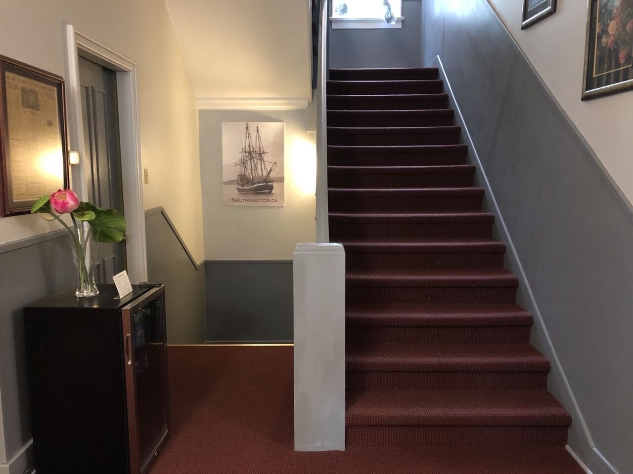 A staircase with red carpeted steps leading to a landing.