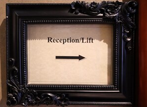 A framed sign with "Reception/Lift" and an arrow pointing to the right. - Dreamtel London Kensington (London)