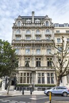 Ein mehrstöckiges Gebäude mit aufwendiger Architektur, darunter ein prachtvoller Eingang und mehrere Balkone.