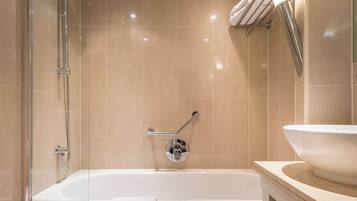 Een moderne badkamer met een bad, een douche en een wastafel.