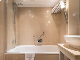Un bagno moderno con una vasca, una doccia e un lavandino.