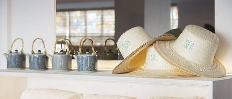 A display of hats and tea sets on a shelf.