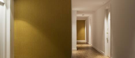 A hallway with wooden flooring and white walls.
