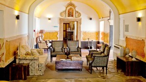 A spacious living area with a high arched ceiling, comfortable seating, and a central coffee table. - Lam Hotel Convento d'Alter (Alter do Chao)