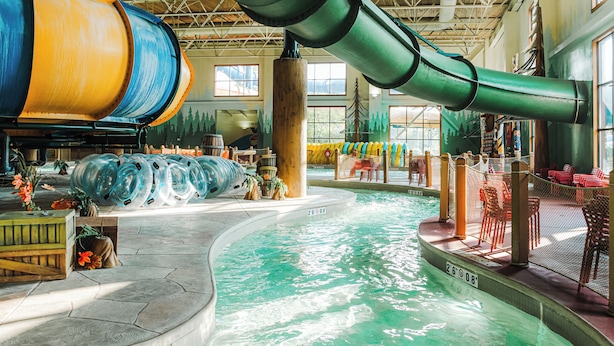 A water park with a large indoor pool, slides, and seating areas. - Great Wolf Lodge Niagara Falls (Niagara Falls)
