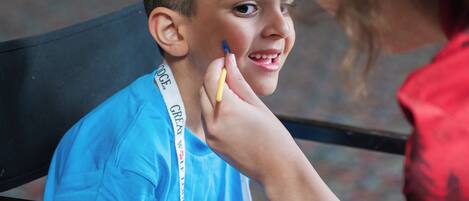 A person sitting on a bench wearing a blue shirt with a lanyard.