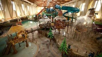 An indoor water park with slides, a pool, and play structures.