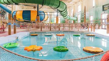 An indoor water park with a large pool, slides, and various water play areas.