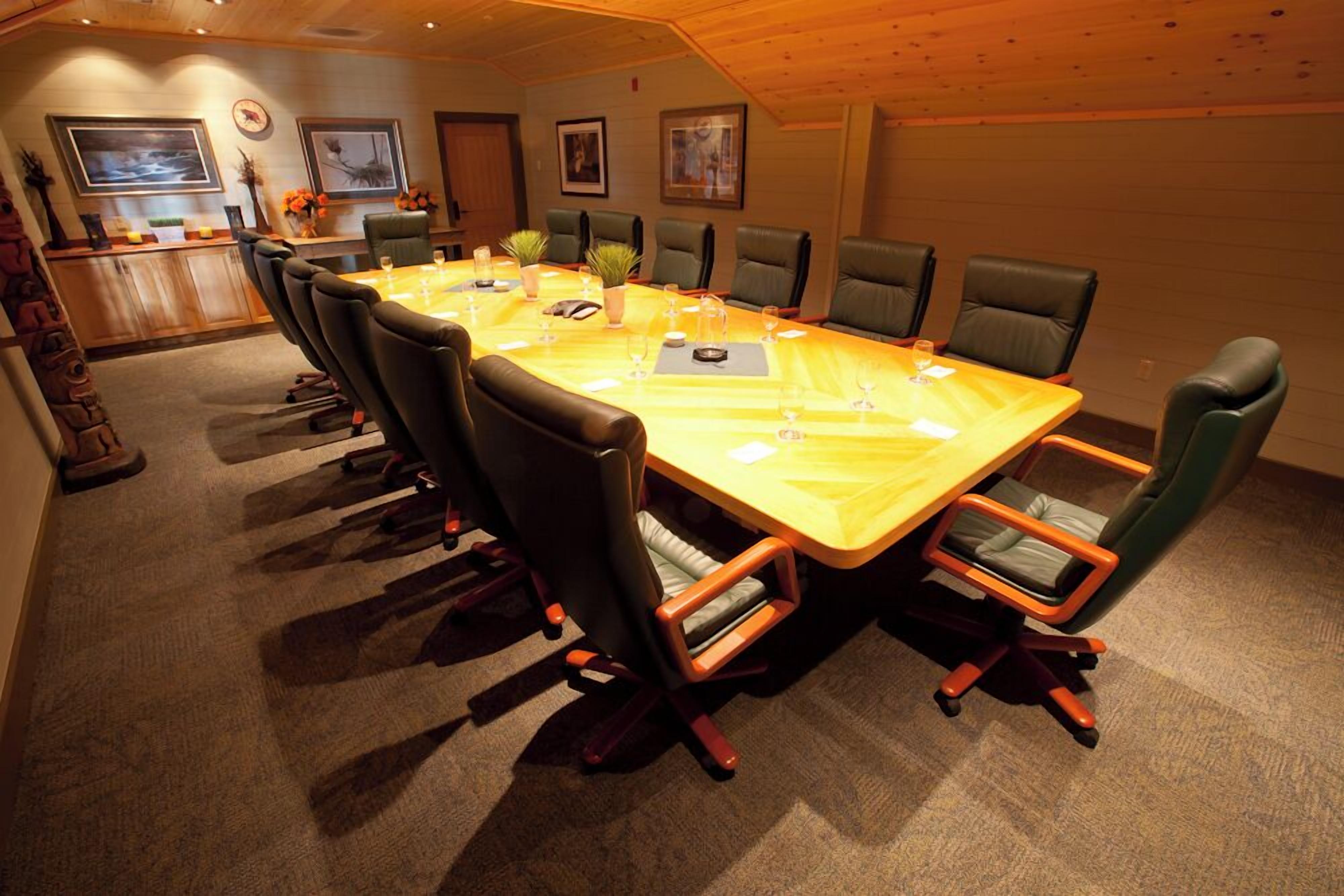 A conference room with a long table, chairs, and a bar area.