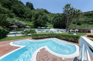 Una piscina al aire libre de temporada, sombrillas