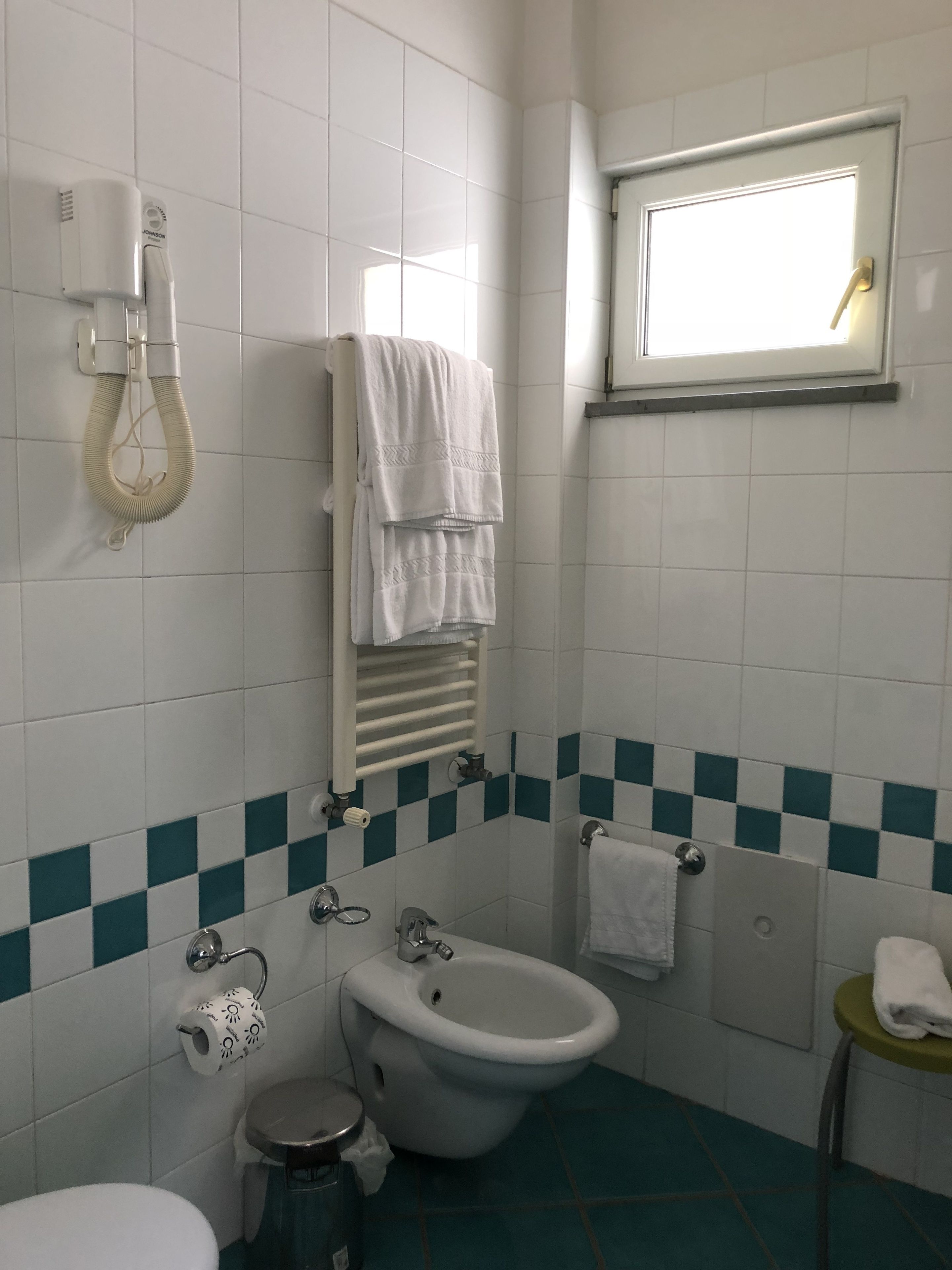 Ein Badezimmer mit Toilette, Bidet und Handtuchhalter.