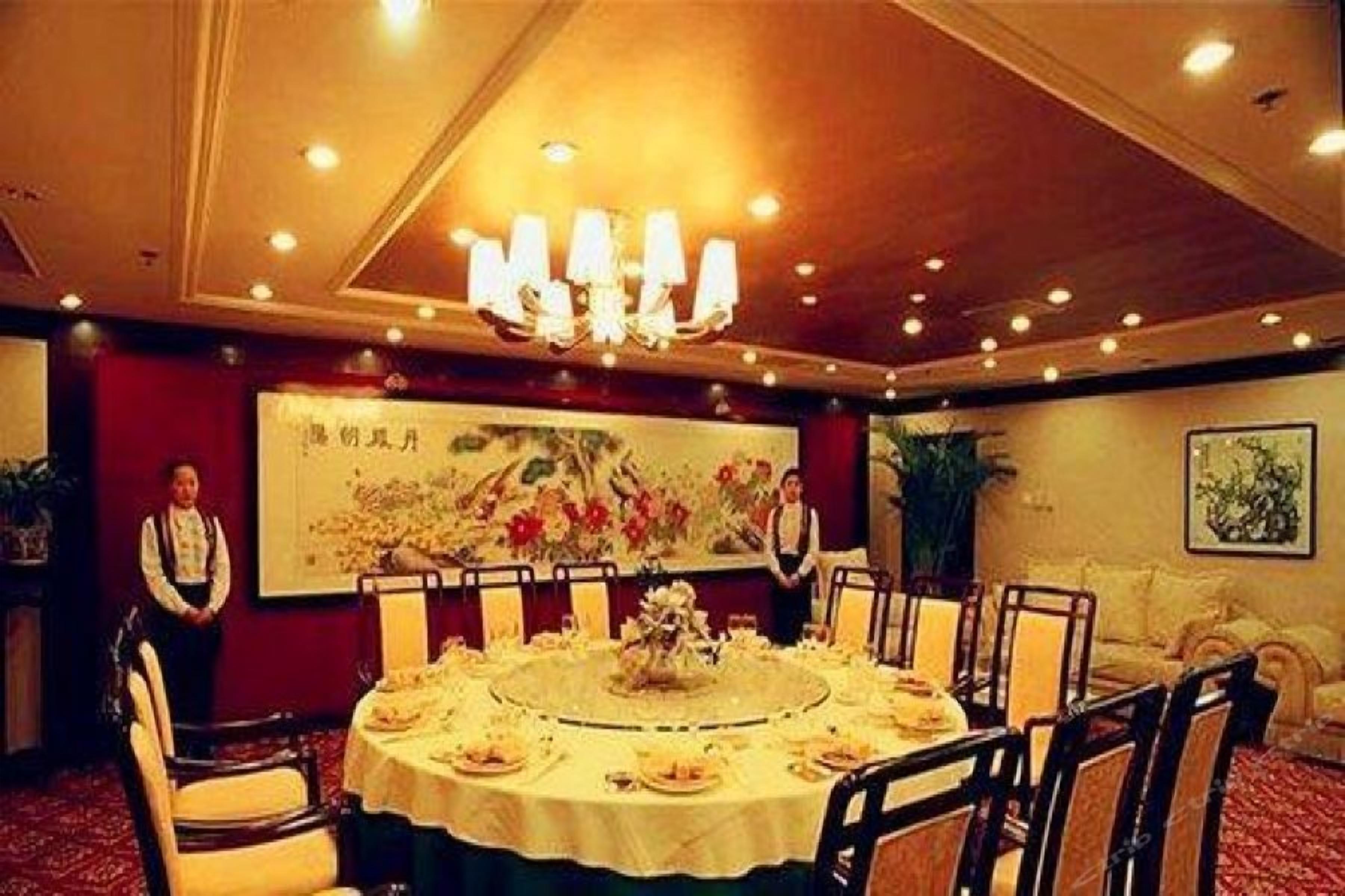A conference room with a round table, chairs, and a chandelier.