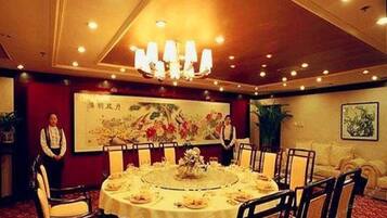 A conference room with a round table, chairs, and a chandelier.