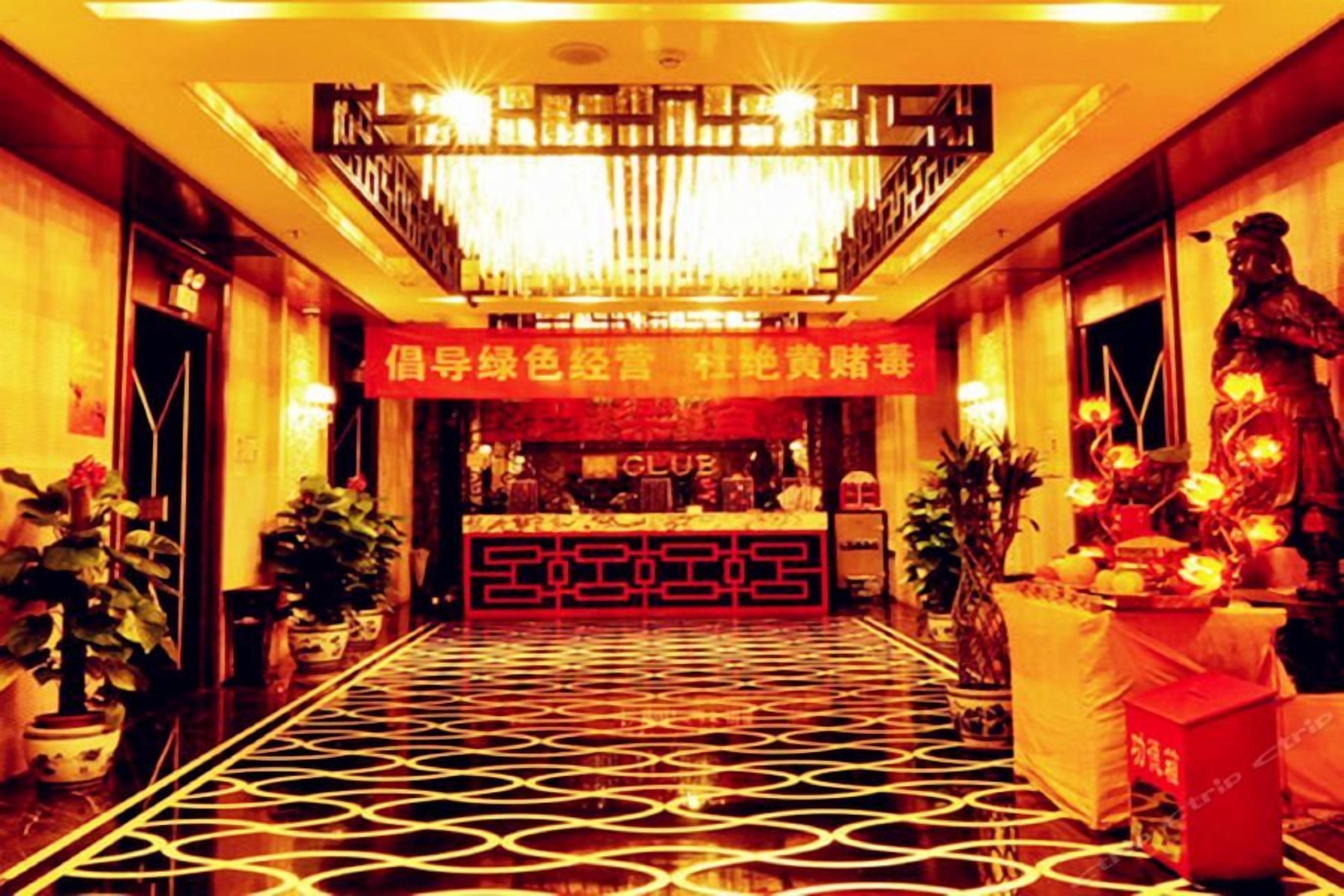 Una hall d'albergo con pavimento decorato, una reception e una statua.