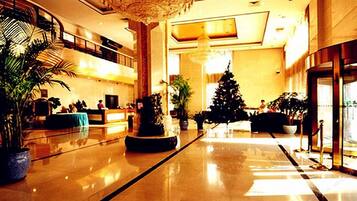 Um lobby espaçoso com teto alto, balcão de recepção e árvore de Natal.