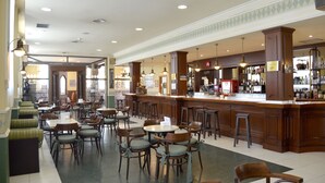 Un amplio bar con muebles de madera y una barra alta.