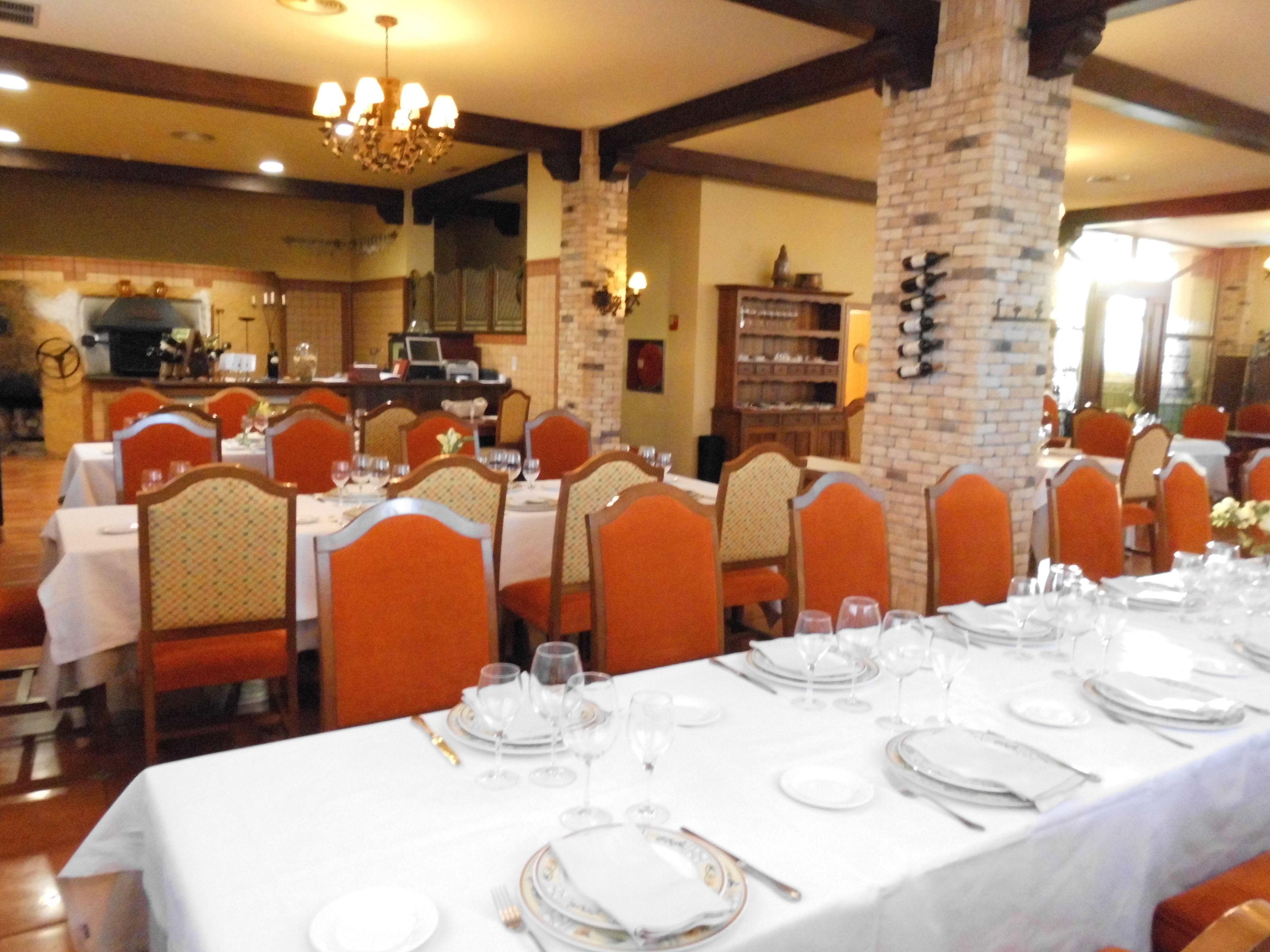 Un restaurante con mesas dispuestas para comer, que cuenta con un pilar de ladrillo y vigas de madera.