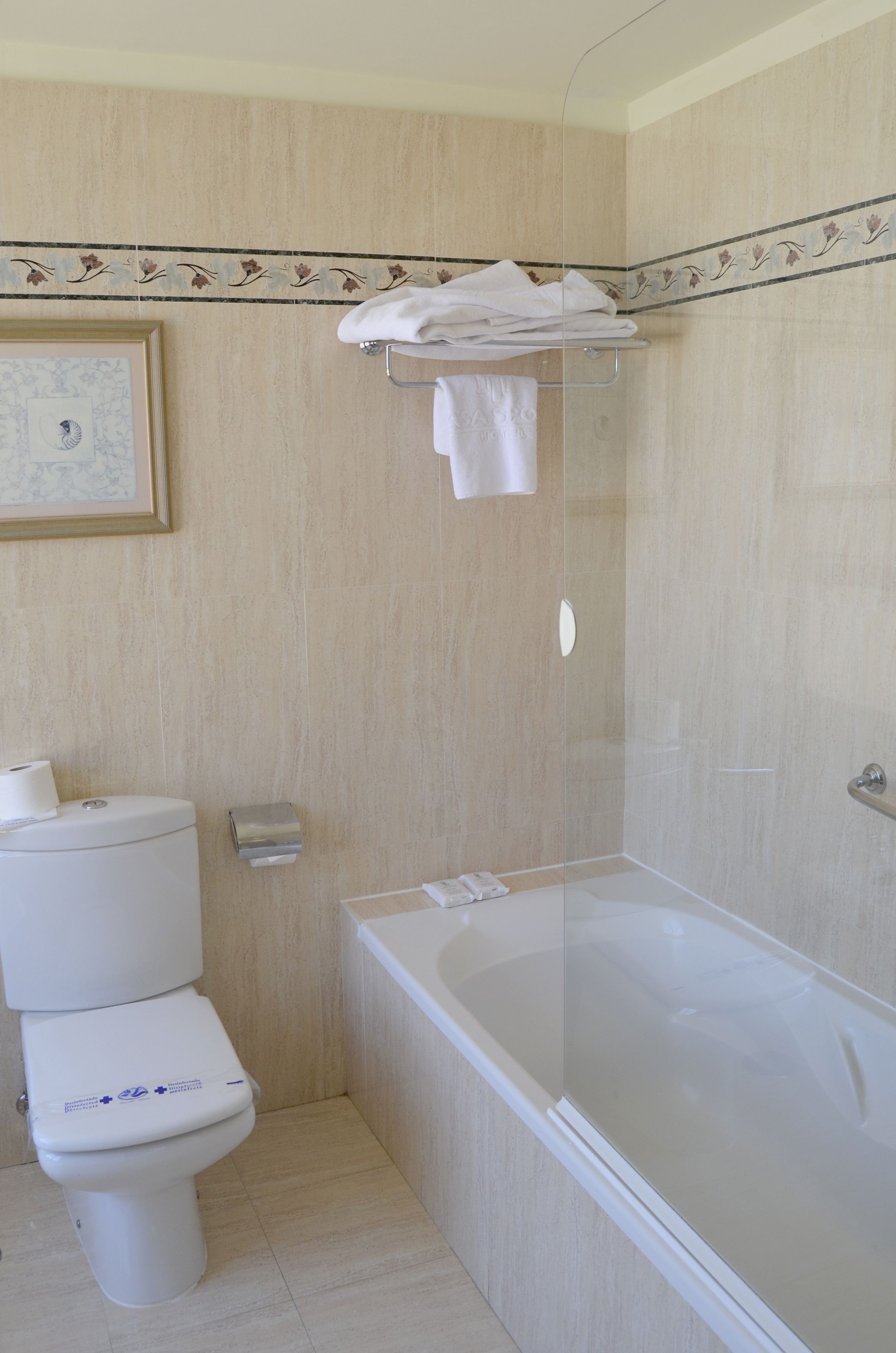 Un baño con inodoro, bañera y toallero.