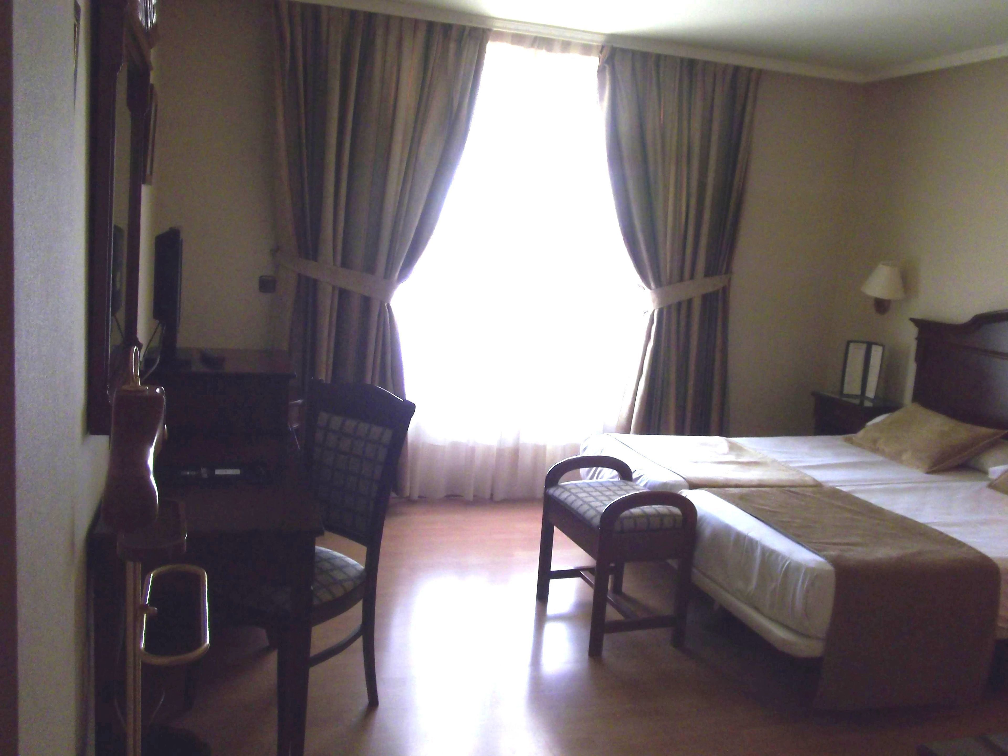 Una habitación de hotel con cama, escritorio y silla.