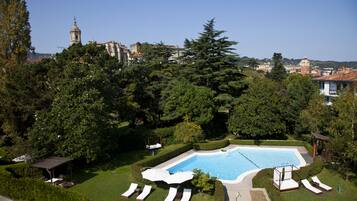 Una piscina al aire libre, sillones reclinables de piscina