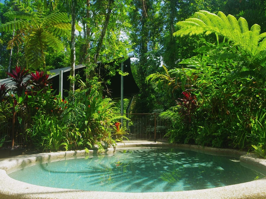 Een buitenzwembad, ligstoelen bij het zwembad