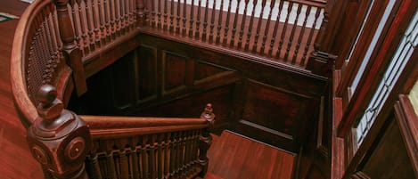 A wooden staircase with a handrail and a landing area.