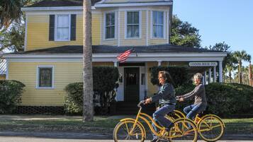 A yellow house with a porch and an American flag.