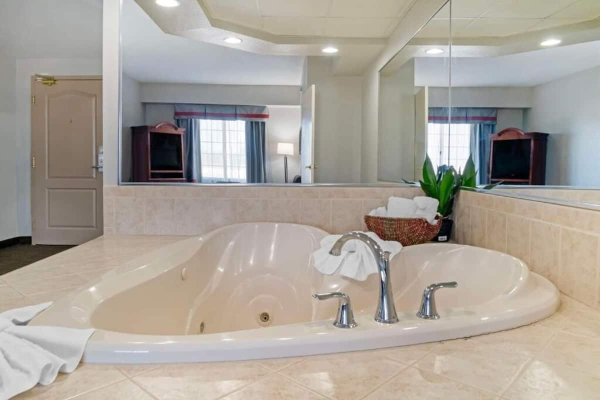 Una bañera grande y ovalada con dos grifos y una toalla.