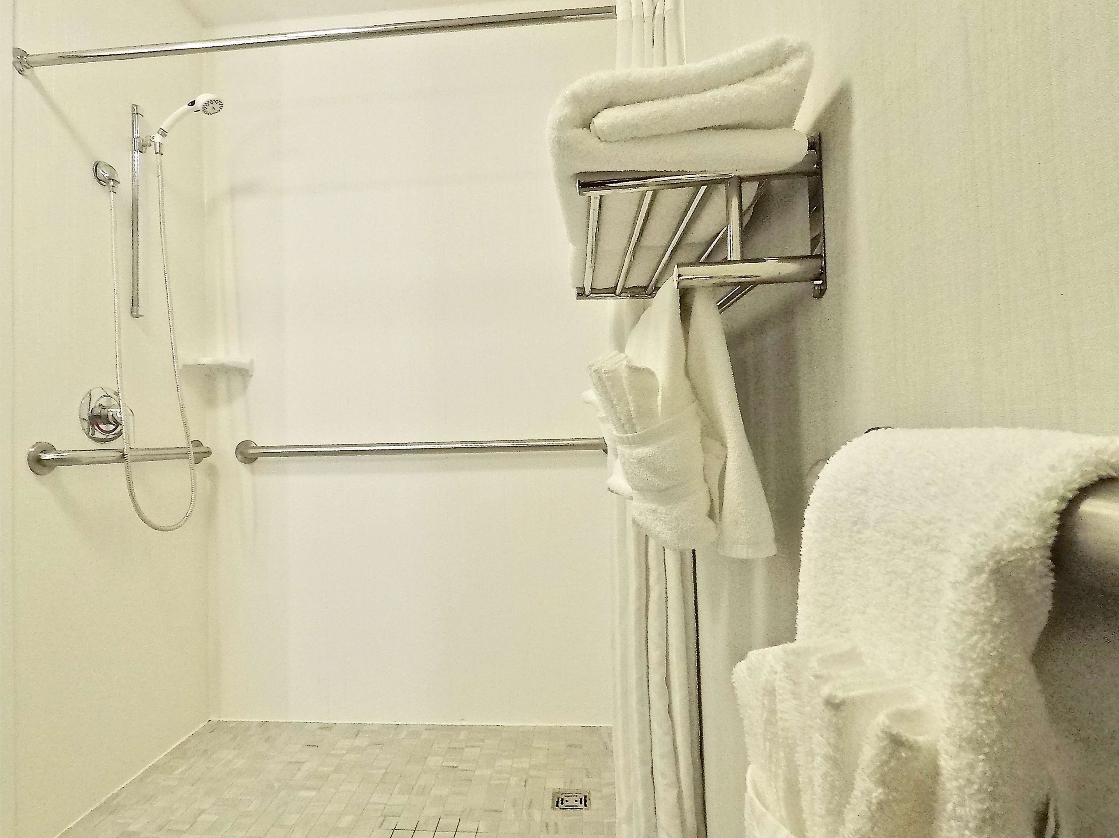 Un baño con ducha, un perchero y una toalla colgada en la pared.