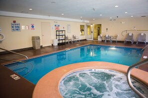 Ein Pool mit Whirlpool, Liegestühlen und Sicherheitshinweisen.
