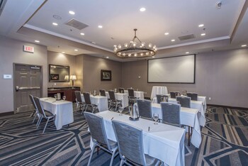 Meetings and presentations take place in this well-appointed conference room, featuring multiple tables and a large screen. at DoubleTree by Hilton North Charleston - Convention Center